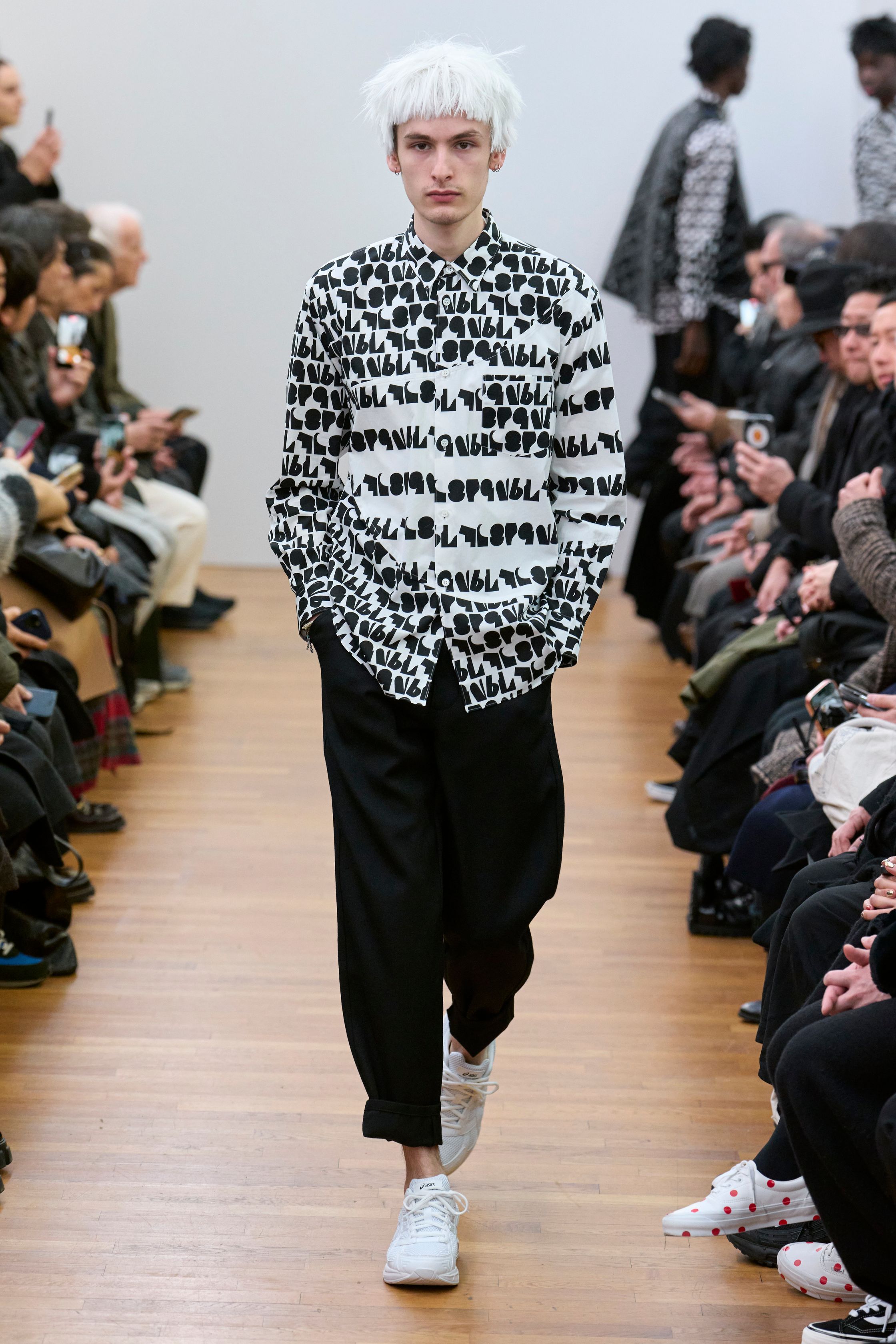 Comme des Garçons Shirt 2026秋冬回到品牌最纯粹的实验原点：衬衫。几何拼接、图形印花与比例错位让日常单品成为视觉符号，色彩克制却充满理性张力。相比 Homme Plus 的激进，这一系列更像冷静的平面设计实验，用“穿着的秩序”探讨日常与先锋的边界-顽石频道趋势研究
